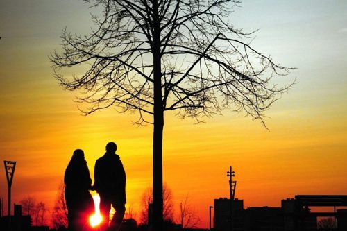 Beautiful sunset and couple walking holding hands